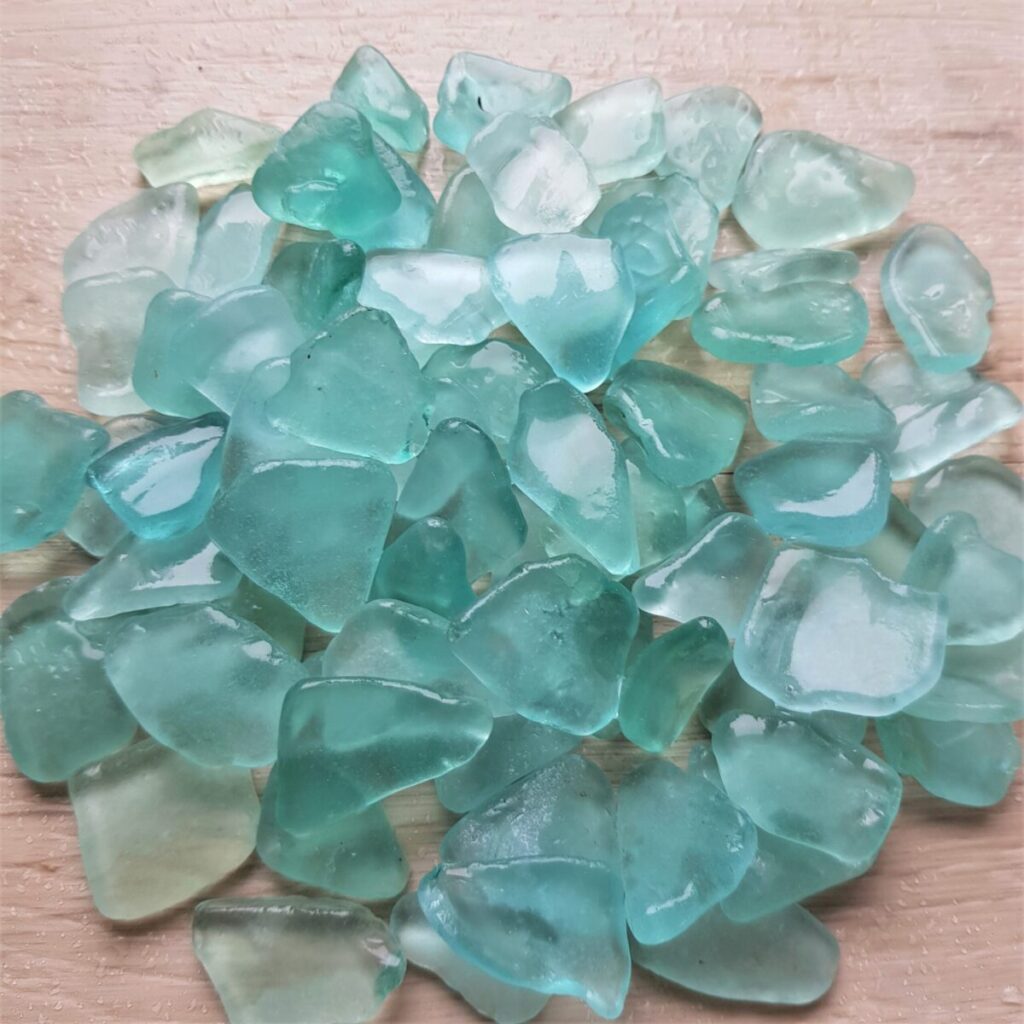 A collection of sea foam sea glass pieces scattered on a smoothig surface