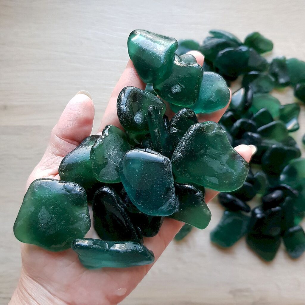 A close-up of teal sea glass pieces glistening in natural light