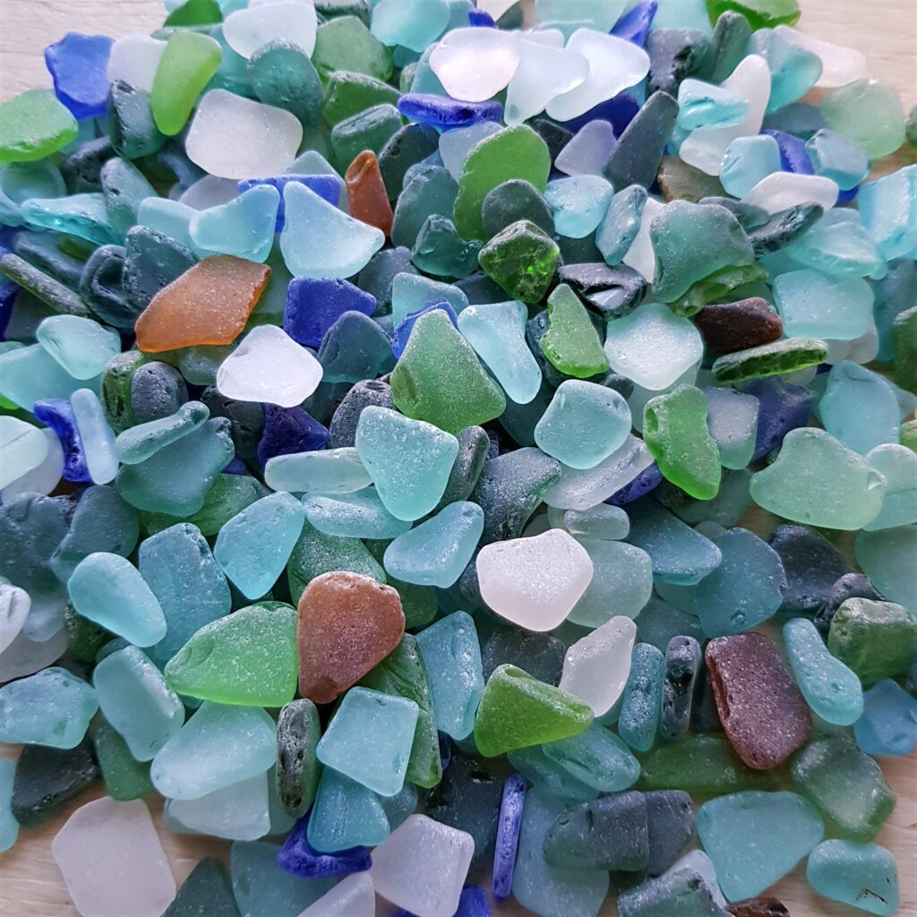 Close-up of smooth sea glass in shades of blue, teal, white, green, and amber