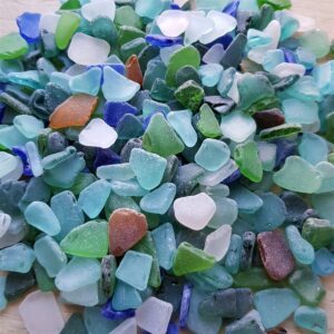 Close-up of smooth sea glass in shades of blue, teal, white, green, and amber