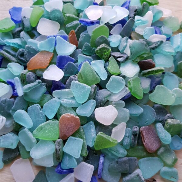 Close-up of smooth sea glass in shades of blue, teal, white, green, and amber