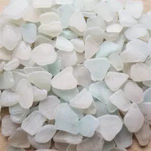 Smooth white sea glass pieces arranged artistically on a neutral background.