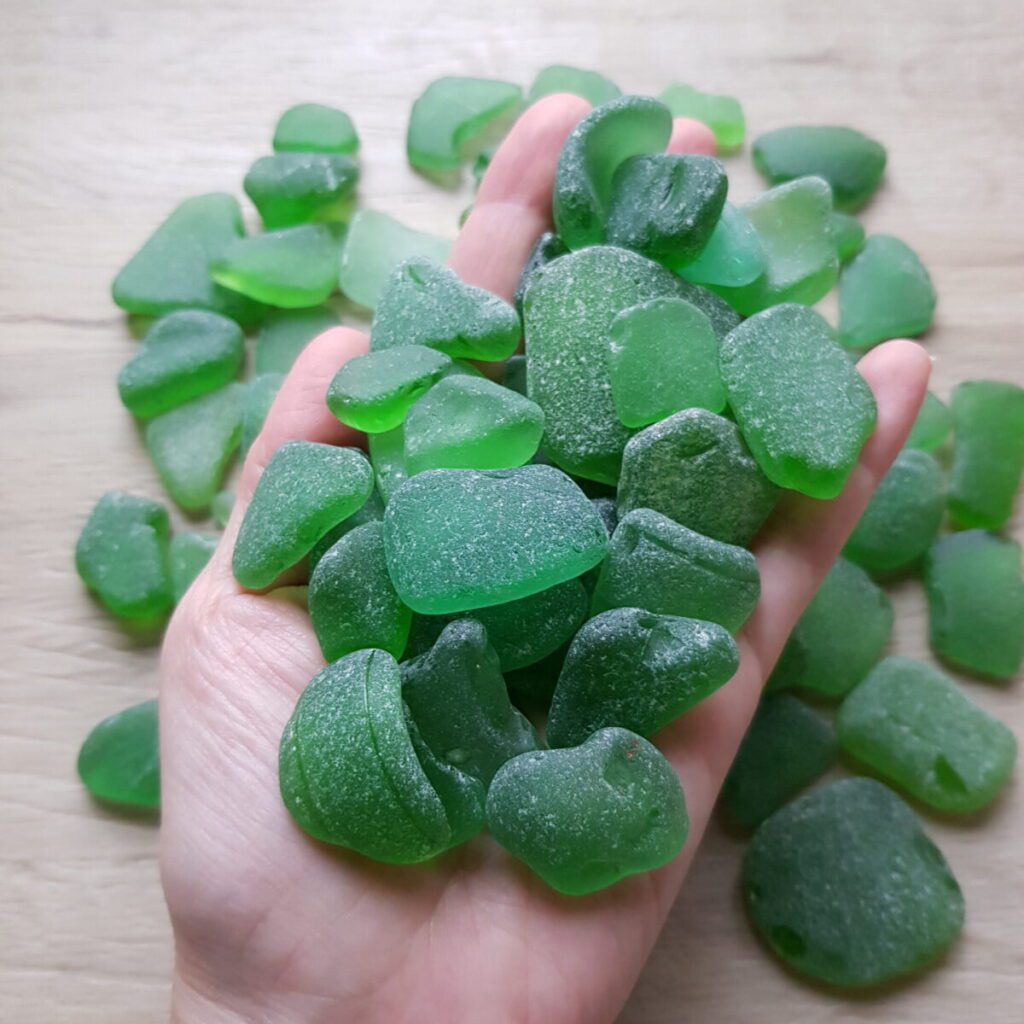 Handful of green sea glass in bulk