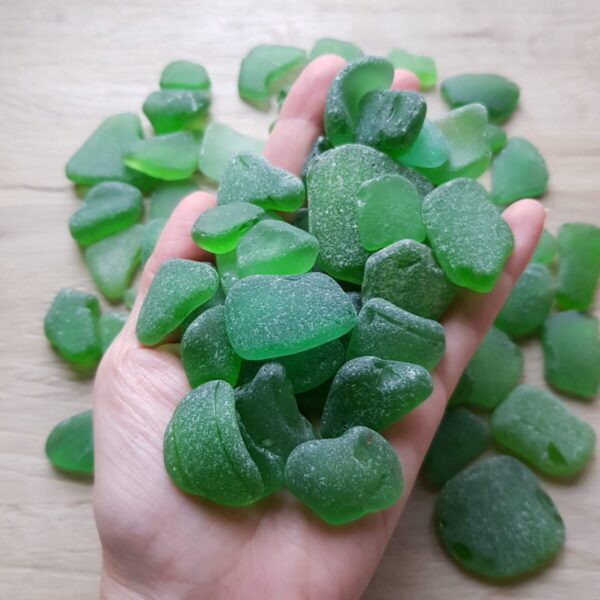 Handful of green sea glass in bulk