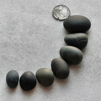 black pebbles with a coin for reference