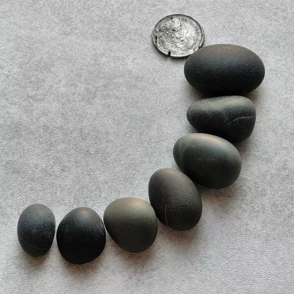 black pebbles with a coin for reference
