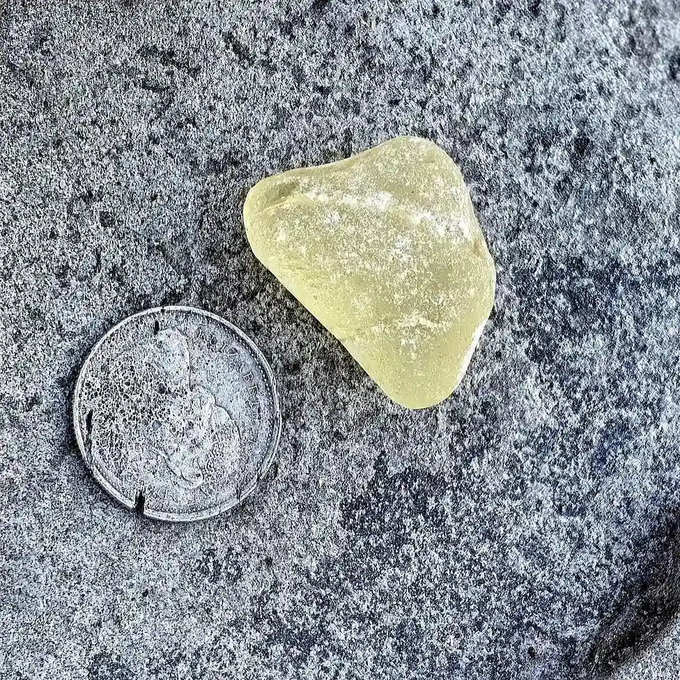 Crackled yellow sea glass displayed oa a stone