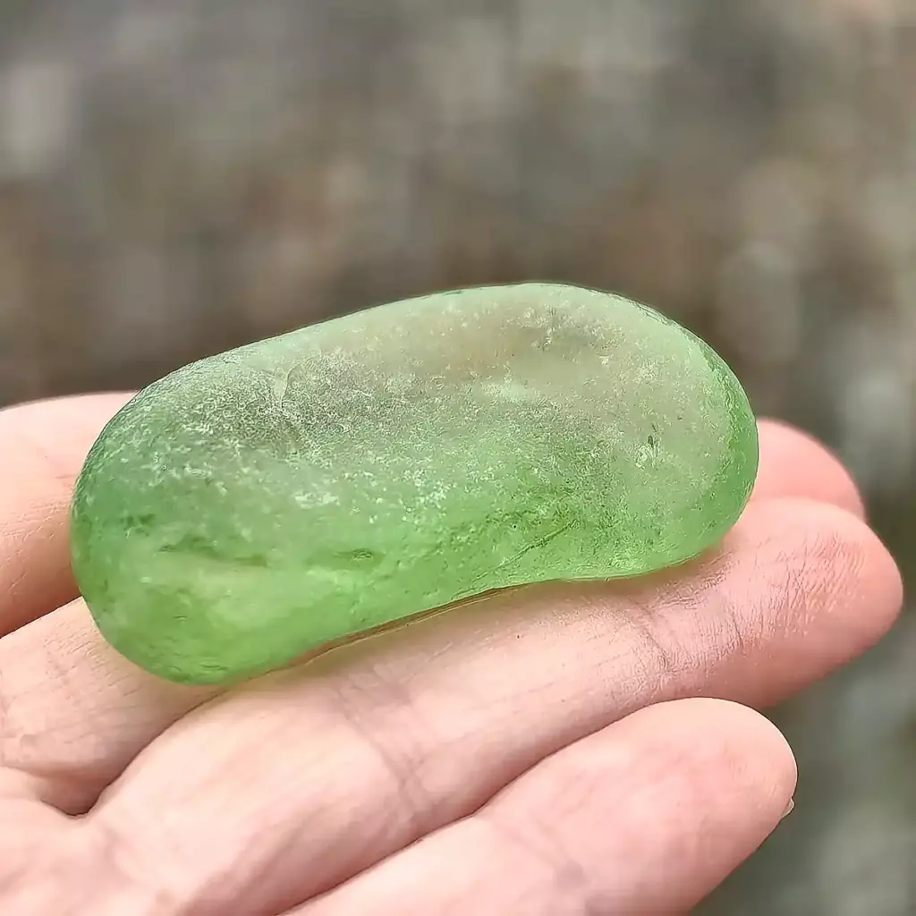 Partial green bottom displayed on a hand