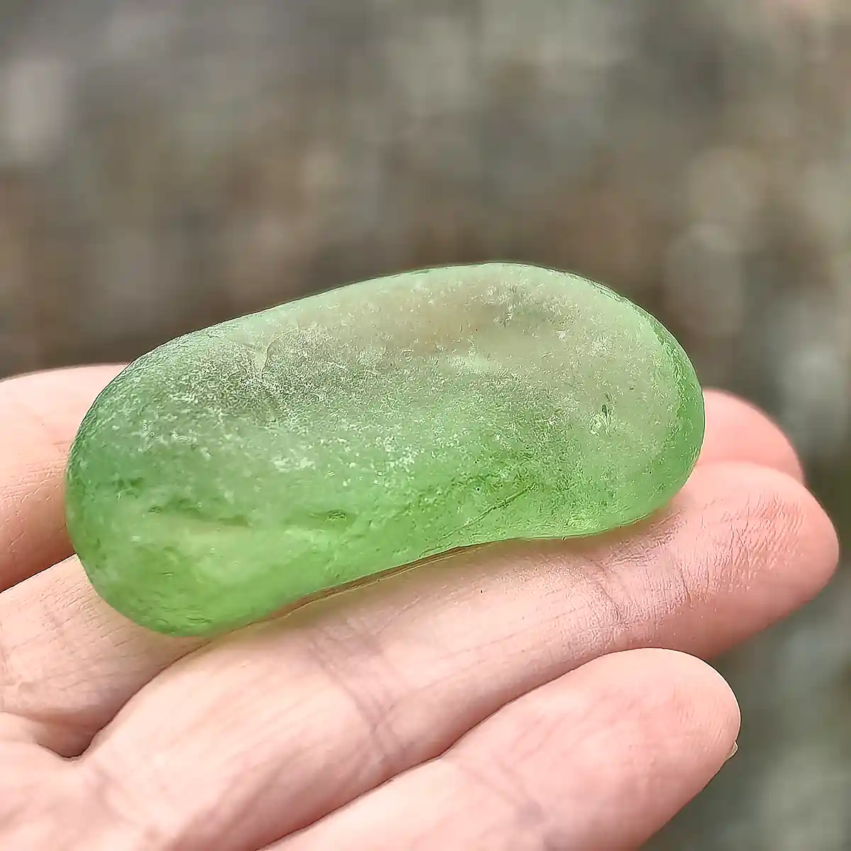 Partial green bottom displayed on a hand