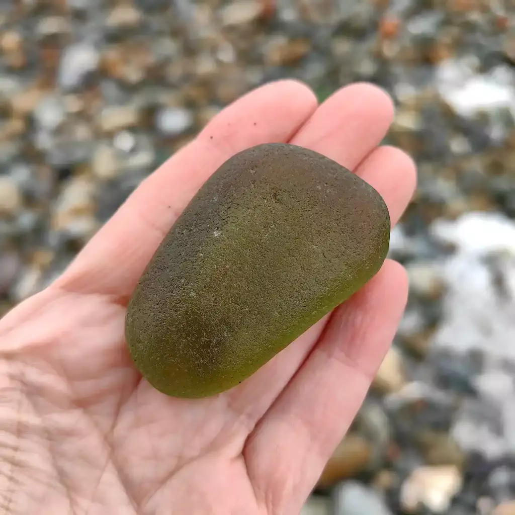 Extra Large Olive sea glass displayed on a hand