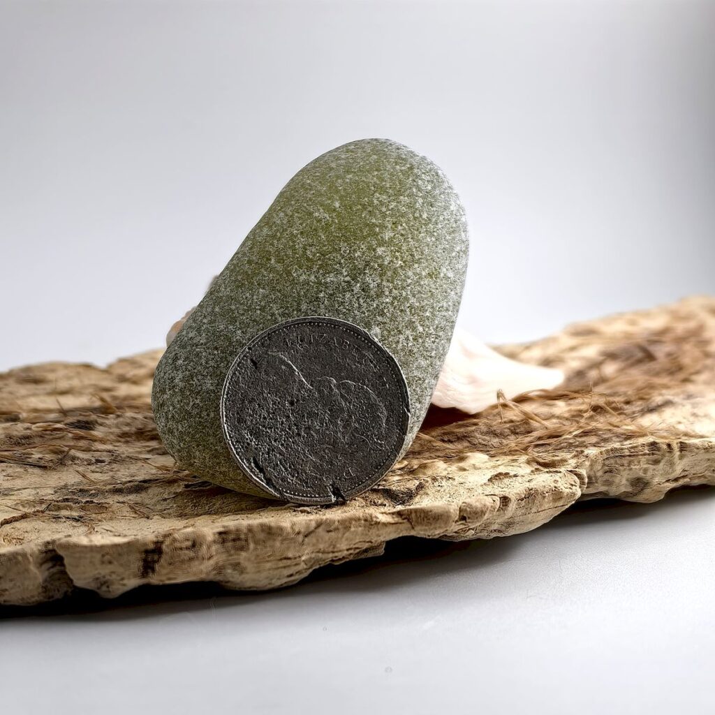 Extra Large Olive sea glass displayed on a driftwood