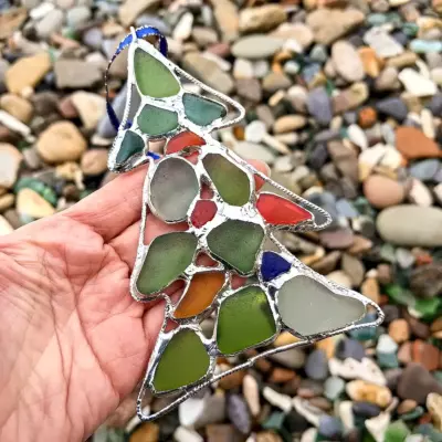 Sea glass Christmas tree suncatcher displayed on a hand