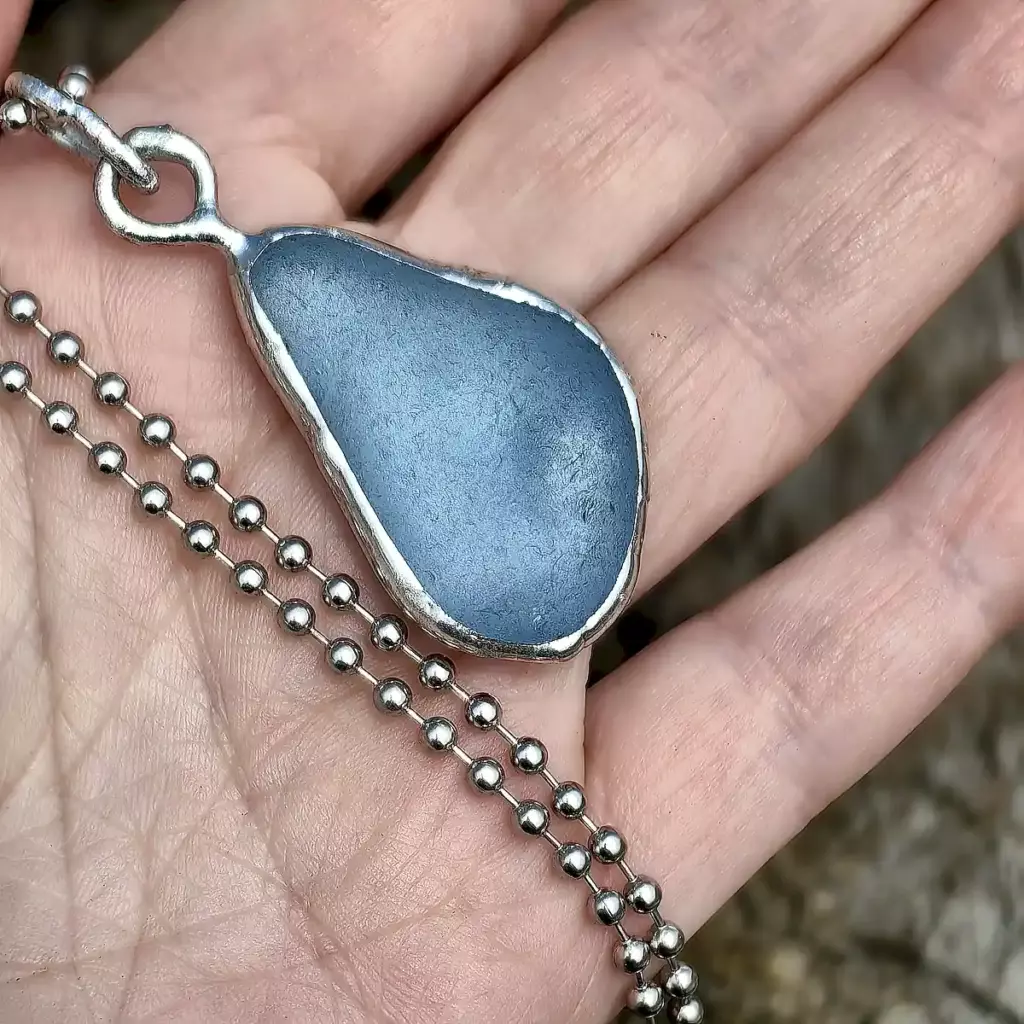 Blue Raindrop Pendant displayed on a hand