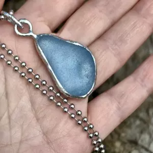 Blue Raindrop Pendant displayed on a hand