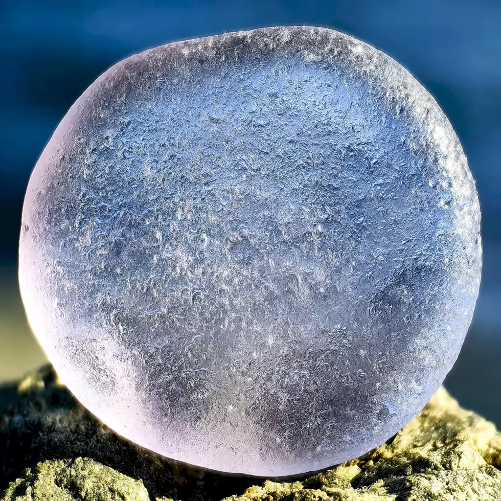 Macro view of Neodimium Sea Glass with hydration marks.