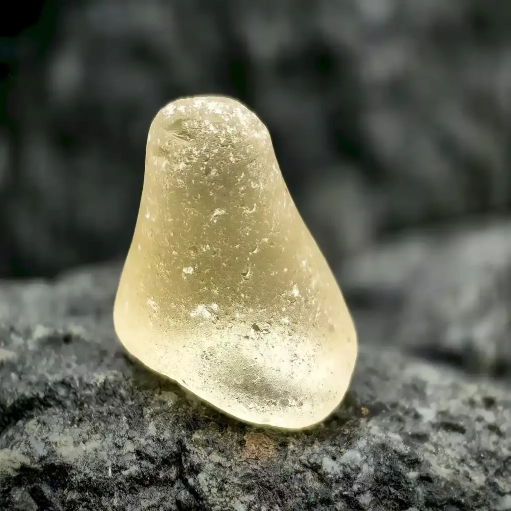 Genuine Rare Russian Yellow Sea Glass resting on the stone